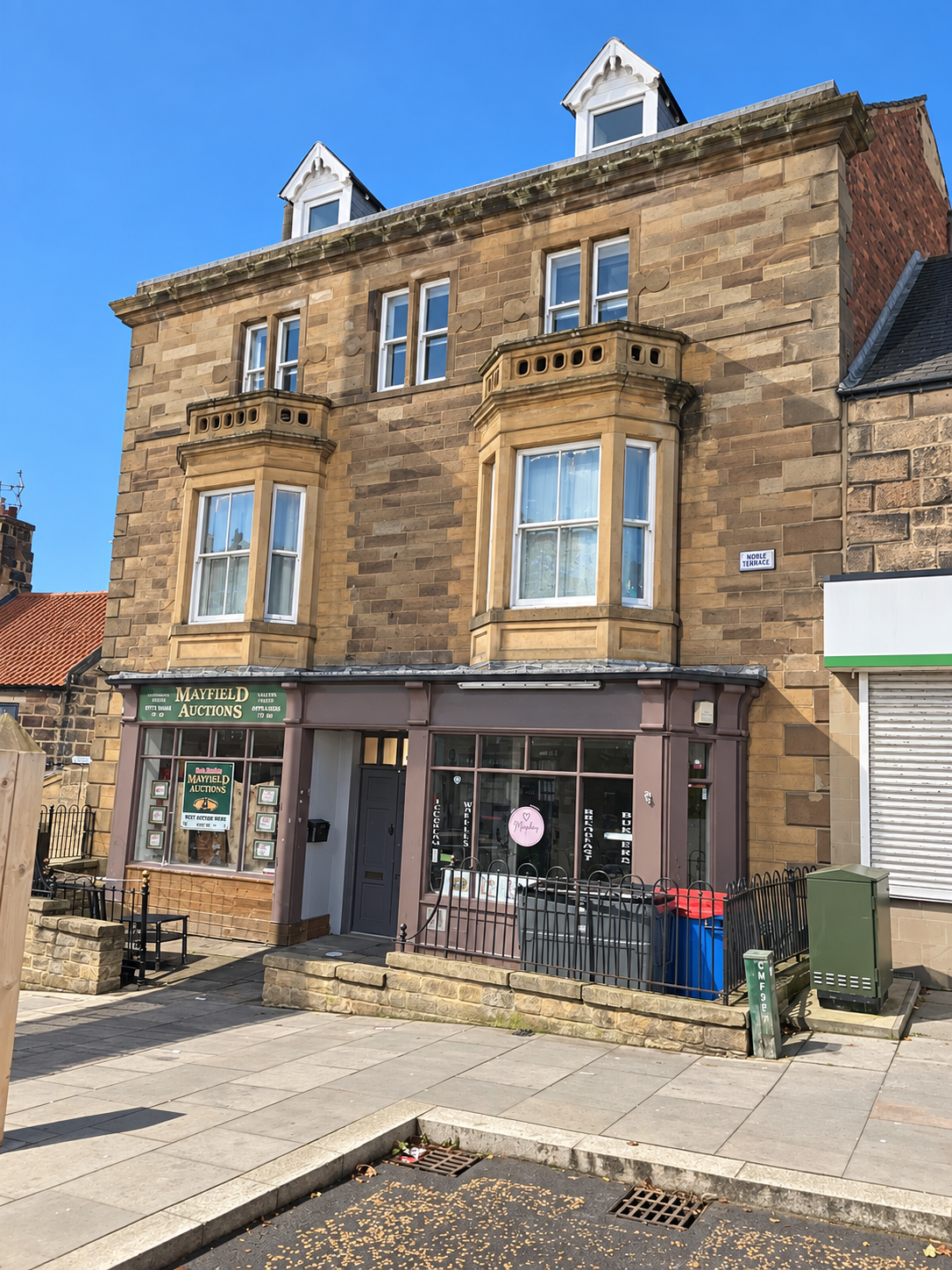 The stone building housing The Kesi apartments in Loftus Market Place, with a clear blue sky